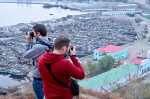 Two tourists taking photos at Chongjin Harbour. | North Korean beaches