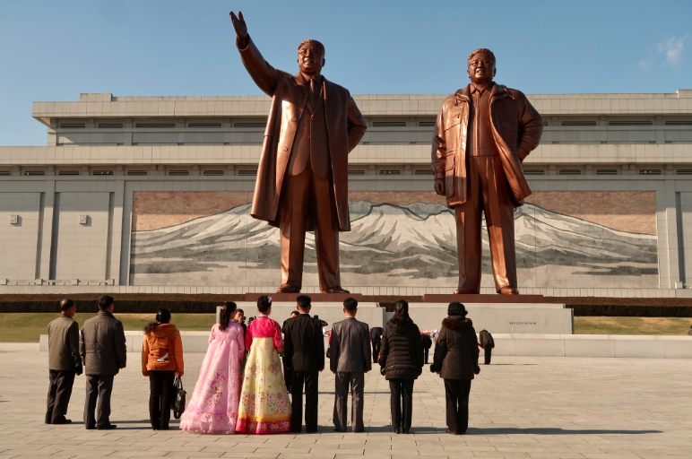 A group of Koreans regard the monuments of Kim Il Sung and Kim Jong Il at Mansudae Grand Monument.