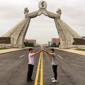 Two men imitate the pose of the Arch of Reunification on the Thongil Highway, just outside Pyongyang.  -- Korean unification