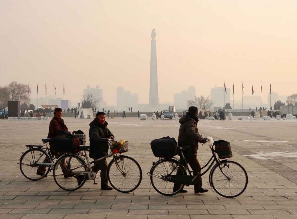 Cycling people walking next to Kim Il Sung Square during winter