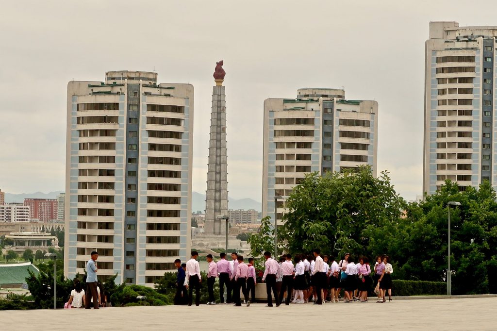 A group of North Korean students walks by the Juche Tower in Pyongyang