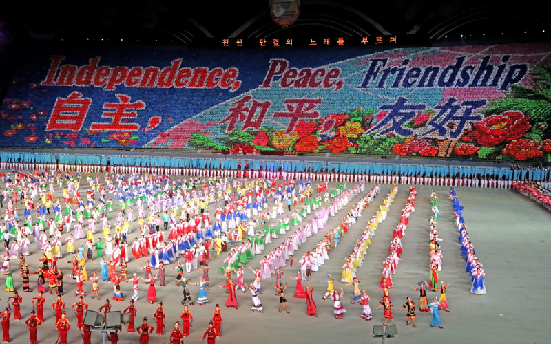 Gymnasts perform under the heading 'independence, peace, friendship' in Chinese and Korean