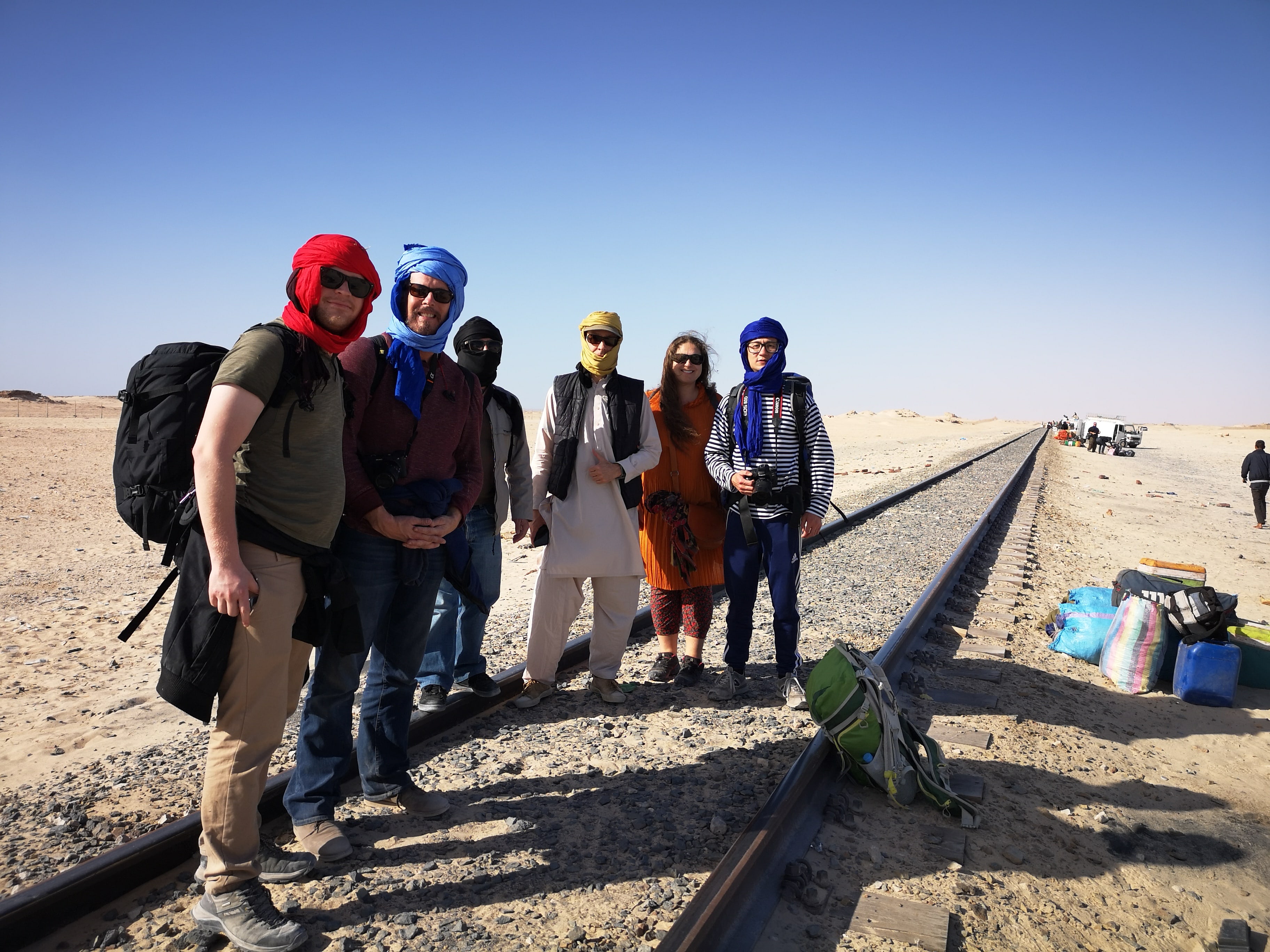 6 people standing on rail way in Western Sahara desert
