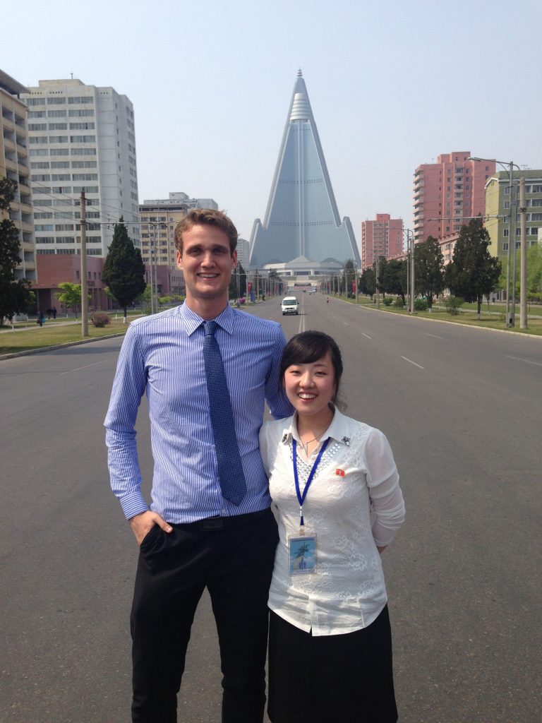 YPT guide rowan is with a local guide in front of the Ryugyong Hotel