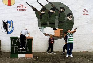 Northern Irish children play with guns in front of an AK-47 mural in Belfast. 