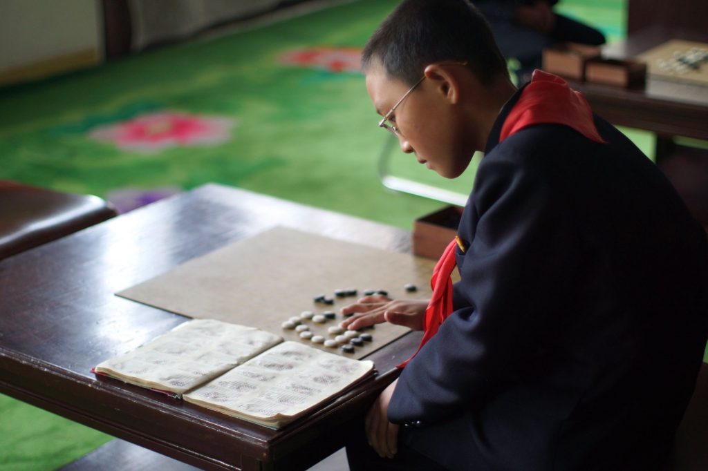 A kid playing Korean chess at the Children's palace