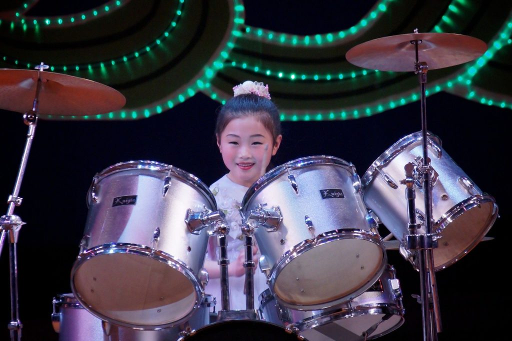 A north korean drummer girl is throwing a performance at the Mangyongdae Children's palace