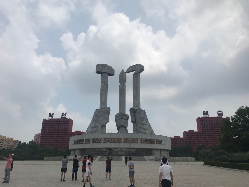 The hammer and sickle are a symbol of many socialist countries today, with the calligraphy brush representing the developments of Juche.