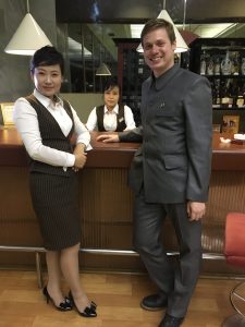 Making a North Korea documentary: Justin, in his North Korean suit, hobnobs with a Korean waitress