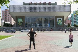 North Korea documentary: Justin Martell stands in front of Kaeson Cinema in North Korea.