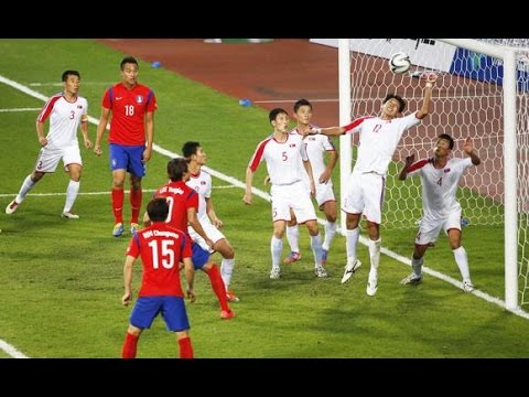 North Korea South Korea football: South Korea head the ball past the North Korean defenders in the 2014 Asian Cup. 