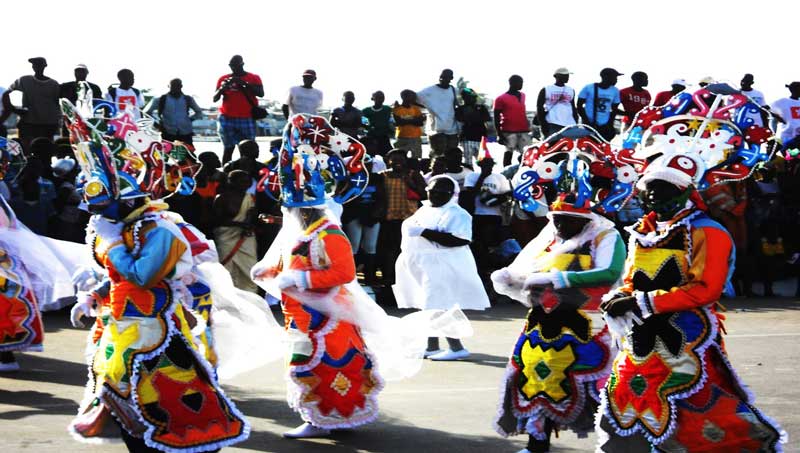 Onlookers watch as Angolan Carnival participants dance by.