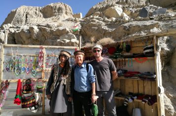 Pamir Highway: YPT guide Troy poses with a Tajik hat vendor along the Pamir Highway.