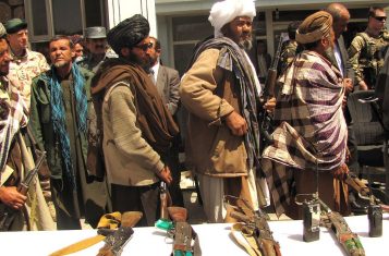 Taliban fighters return their weapons