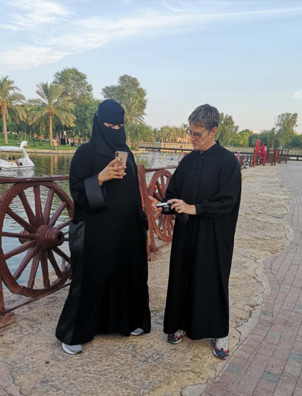 A female traveller in Saudi Arabia picks up a conversation with a local women in a park, in Riyadh