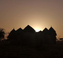The silhouette of a tata house against the sunset