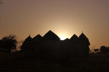 The silhouette of a tata house against the sunset