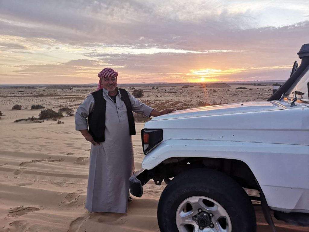 A bedouin guide by his car in the White Desert of Egypt