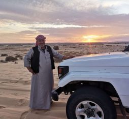 A bedouin guide by his car in the White Desert of Egypt