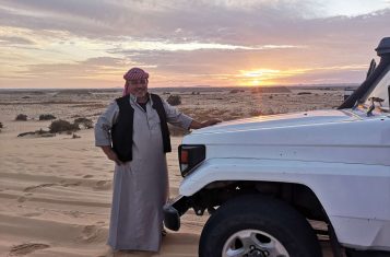 A bedouin guide by his car in the White Desert of Egypt