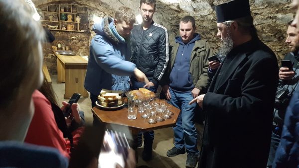 An orthodox priest arranges wine tasting