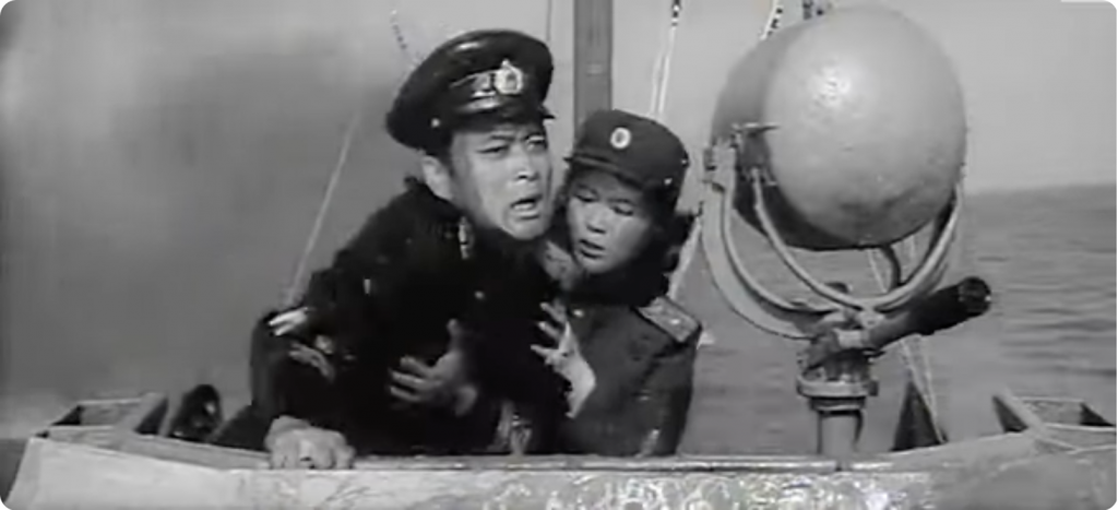 Hye Kyong Steadies Captain Kim After He Is Shot as He Pilots the Boat in the Final Battle with the US